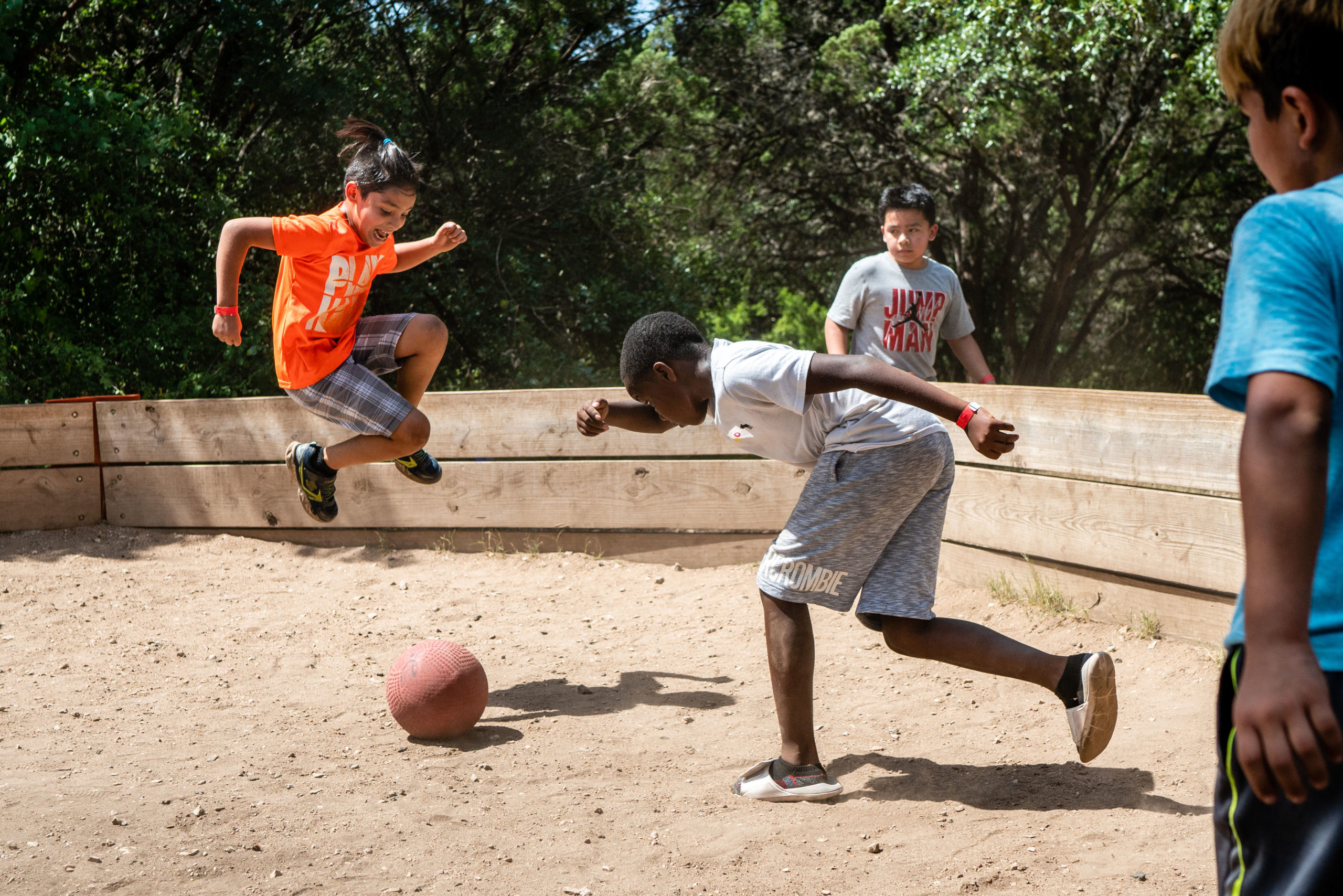 Group of boys playing a game in a sand pit at Austin Sunshine Camps at Zilker Park