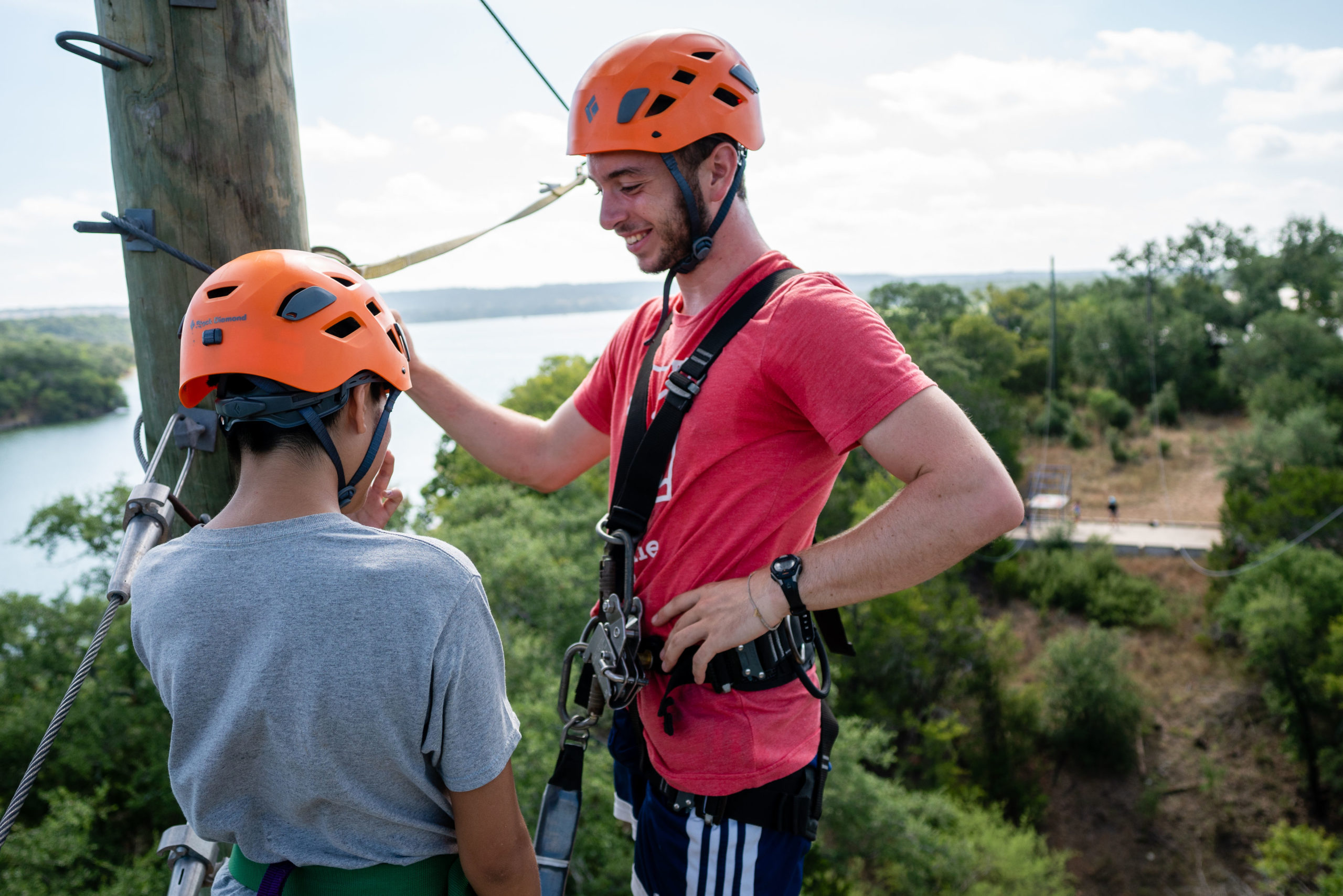 Austin sunshine camps counselor talking with a camper near the zip line