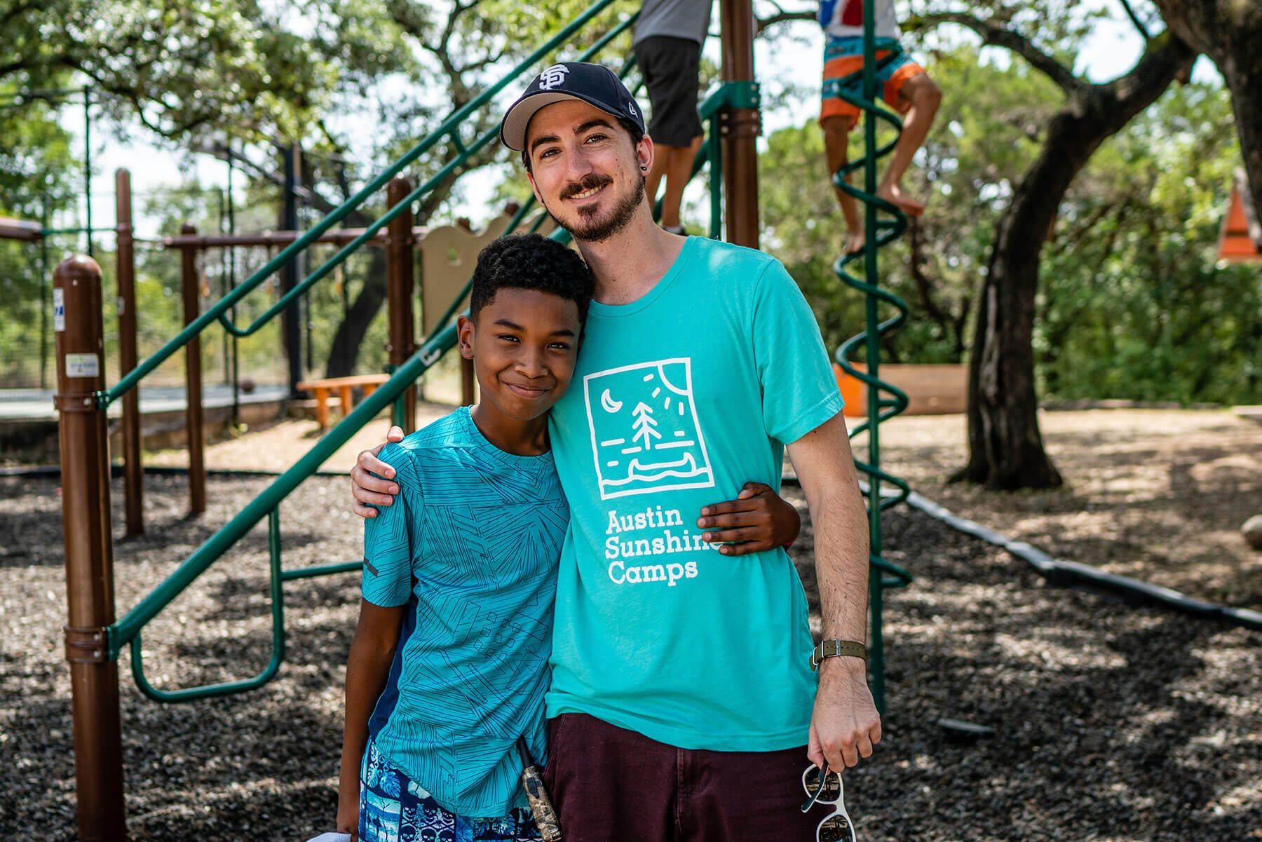 Austin Sunshine Camper tomándose una foto con un consejero de Austin Sunshine Camp