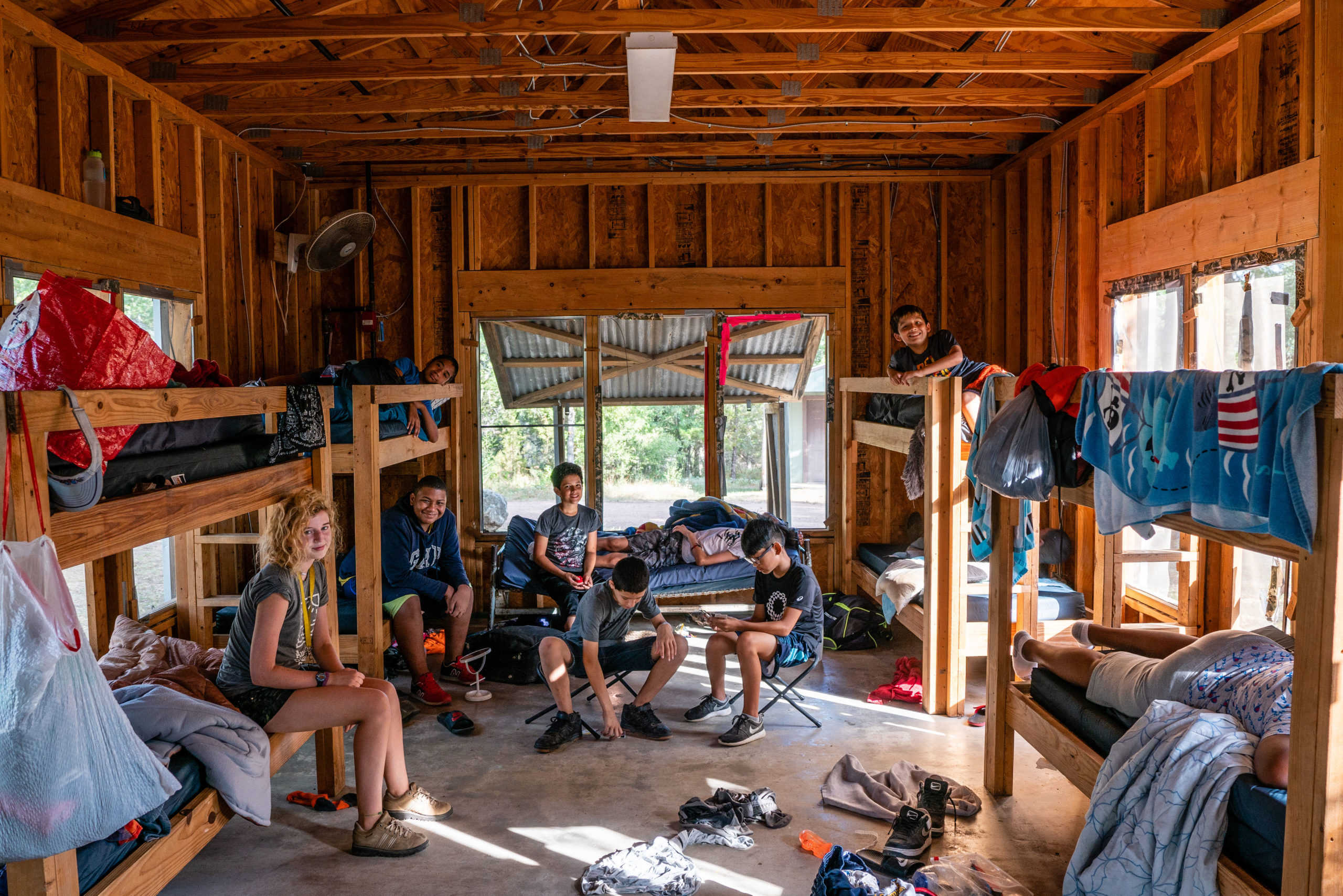 Un grupo de campistas de Austin Sunshine Camp pasando el rato en la cabaña durante el campamento de verano