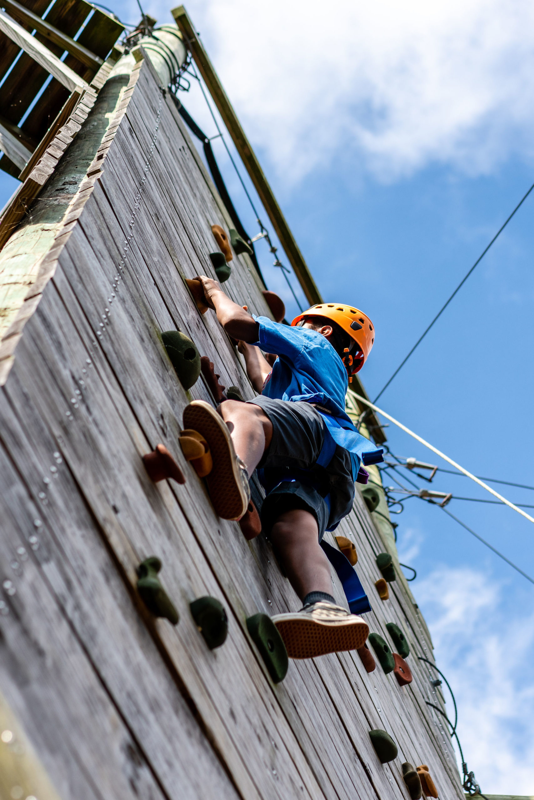 Camper escalando una pared de roca en Zilker Park Summer Camp