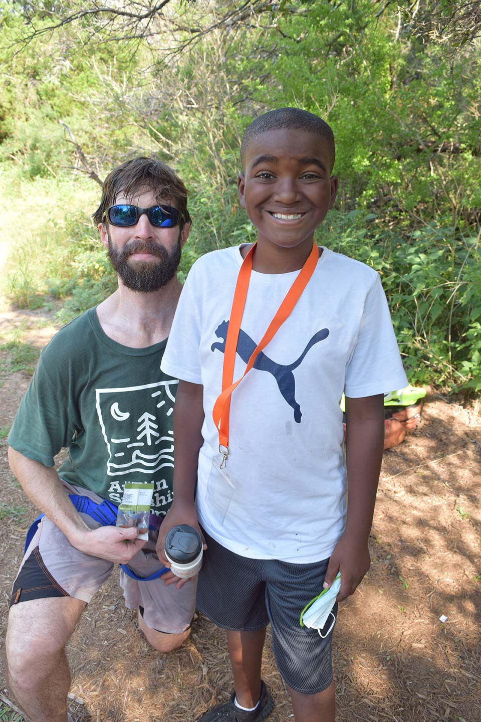 El consejero del campamento de verano de Austin Sunshine Camps se toma una foto con un campista