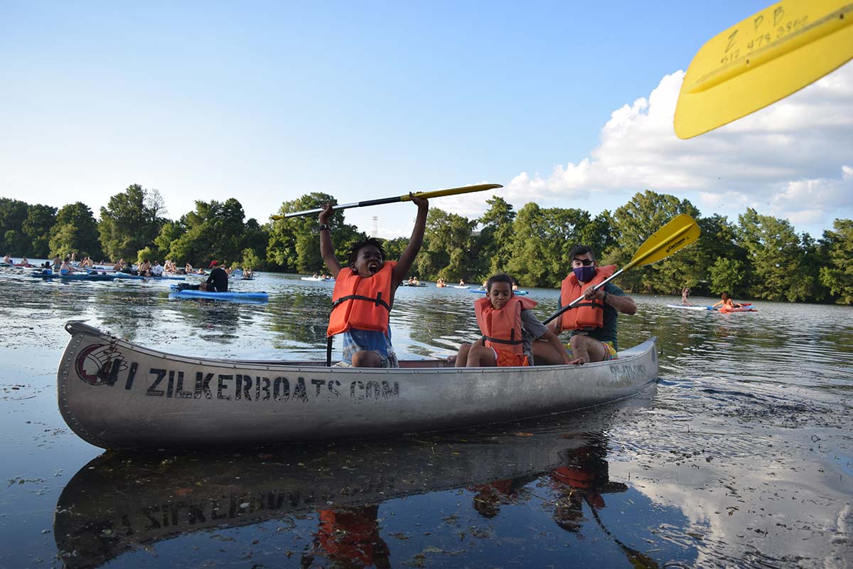 Grupo de campistas de Austin Sunshine Camp remando en una canoa