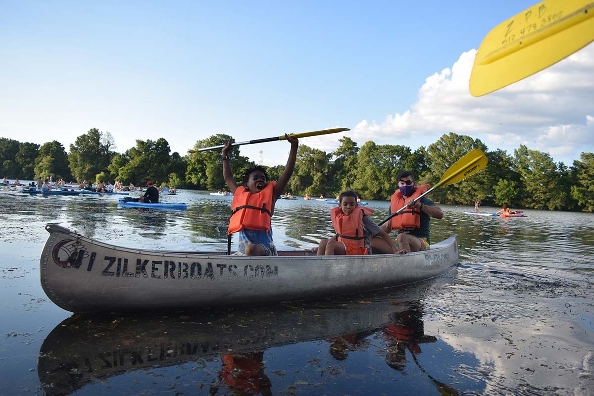 Group of Austin Sunshine Camp campers paddling a canoe