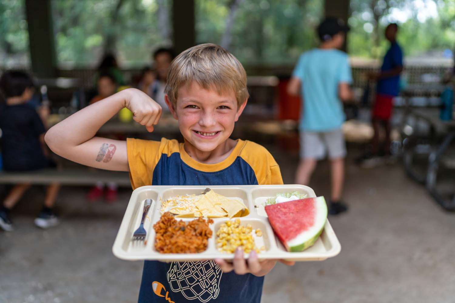 Niño con bandeja de comida.